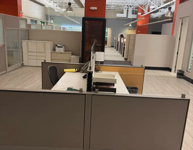 Open coworking workspace with dedicated desks and phone booth at World Park