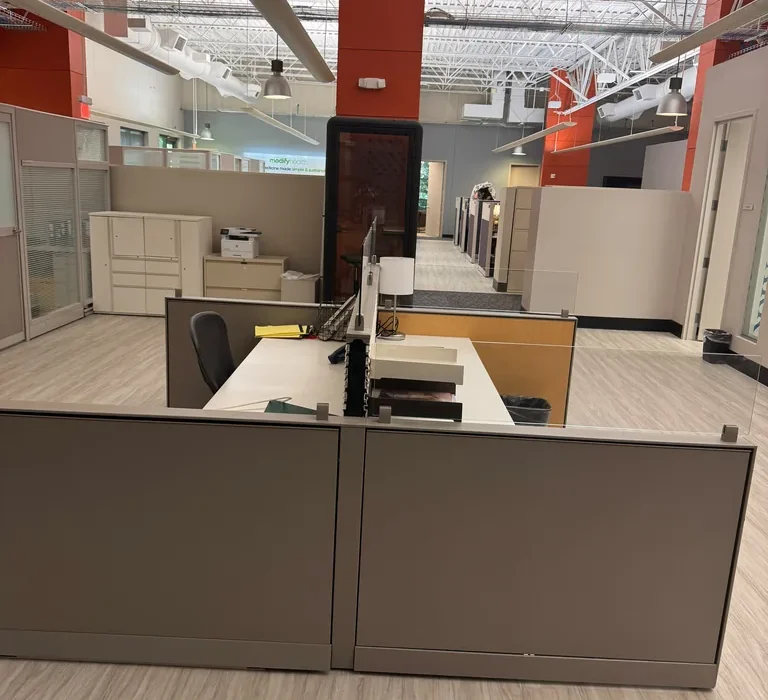 Open coworking workspace with dedicated desks and phone booth at World Park