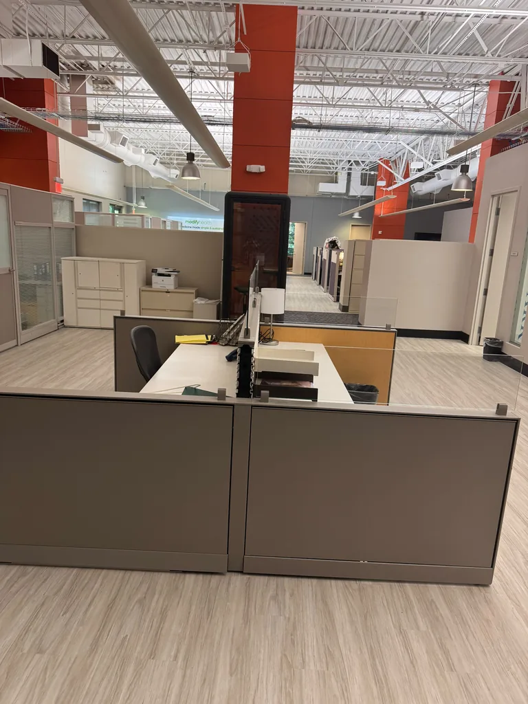 Open coworking workspace with dedicated desks and phone booth at World Park
