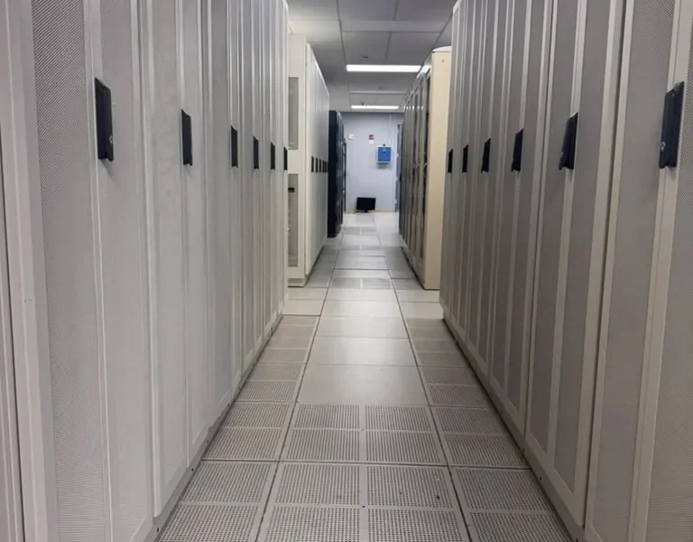 Long aisle of white colocation cabinets with perforated doors at the MarQi Cloud data center in Alpharetta, Georgia