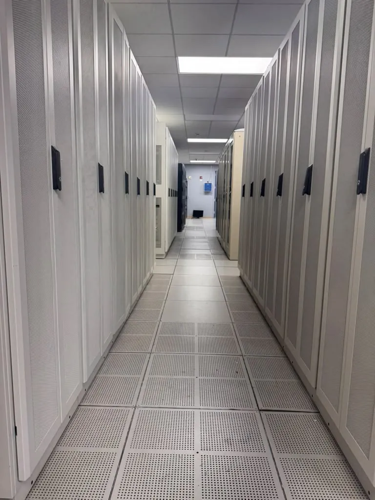 Long aisle of white colocation cabinets with perforated doors at the MarQi Cloud data center in Alpharetta, Georgia